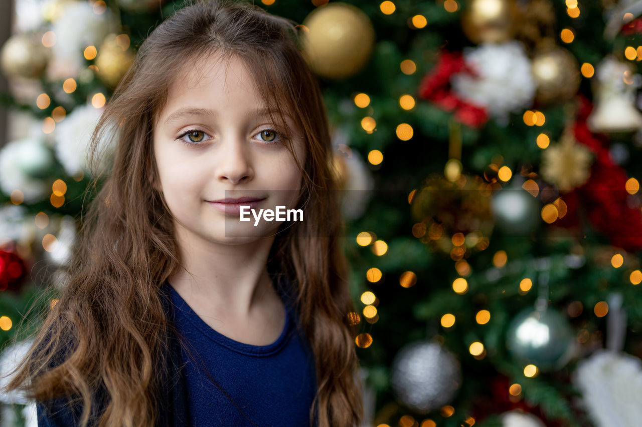 Portrait of girl against christmas tree