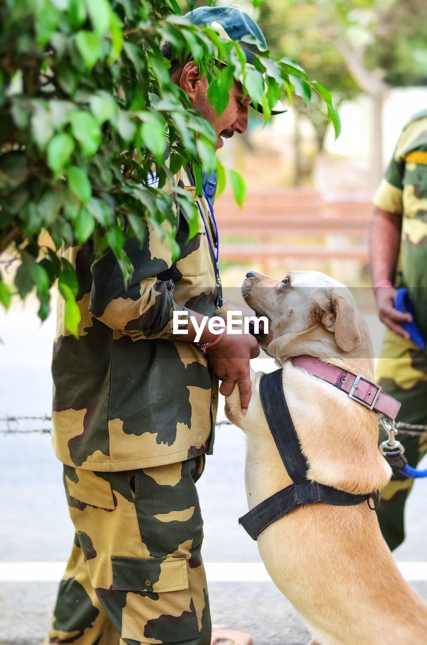 Side view of army soldier with dog