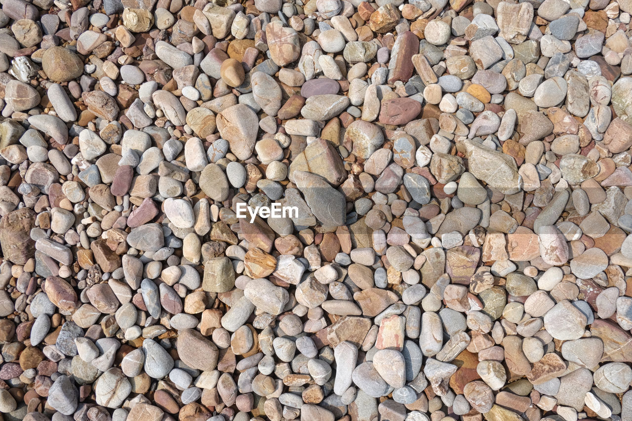 HIGH ANGLE VIEW OF STONES ON PEBBLES