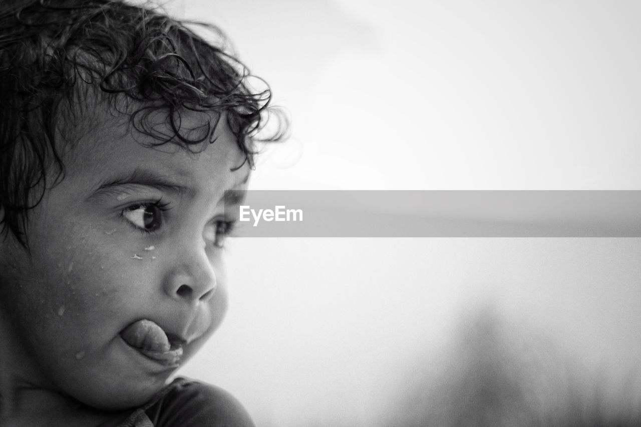 Close-up of wet boy sticking out tongue during rainy season