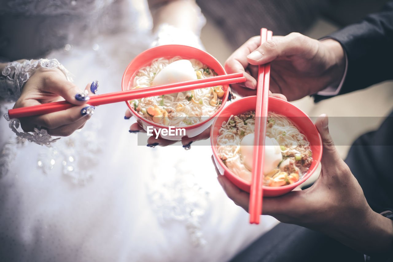 Close-up of hands holding noodle soup