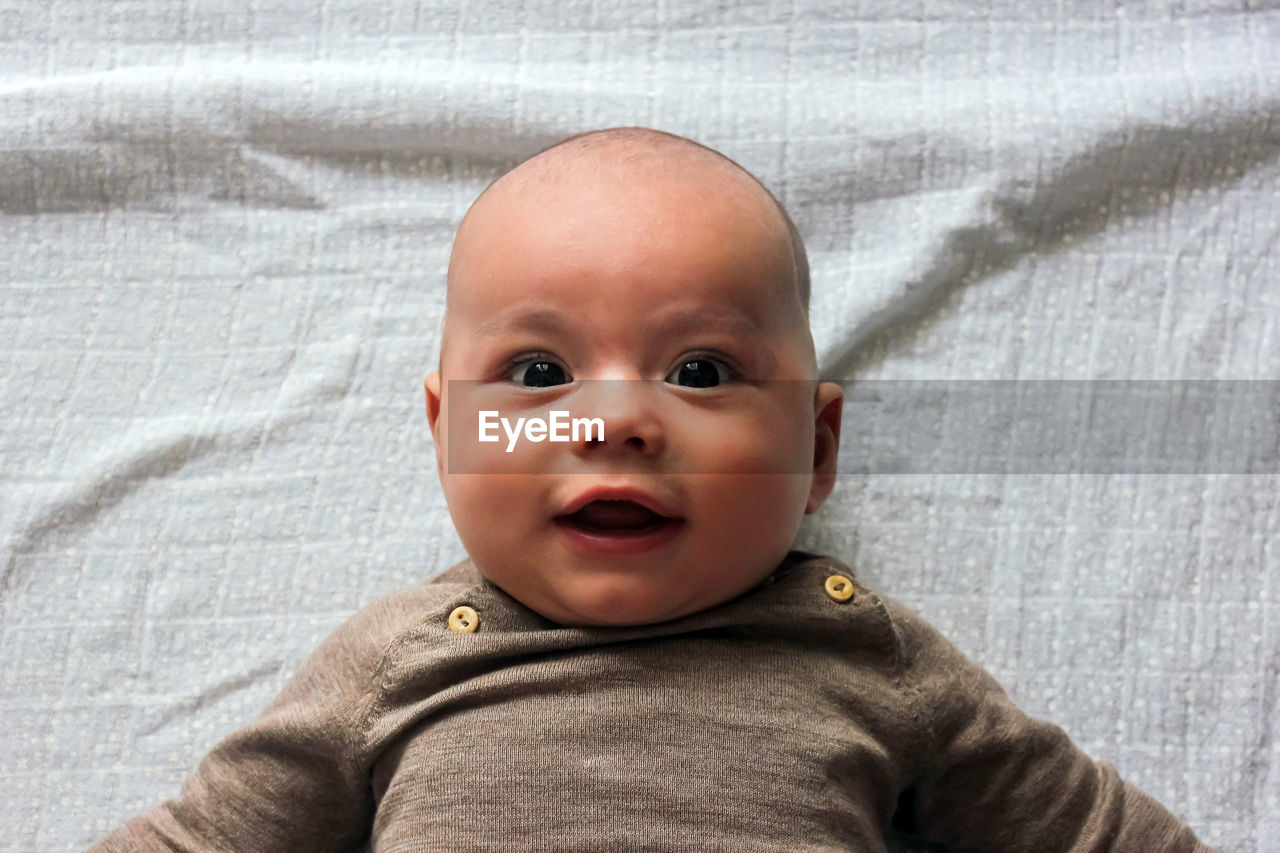 Close-up portrait of cute baby on bed