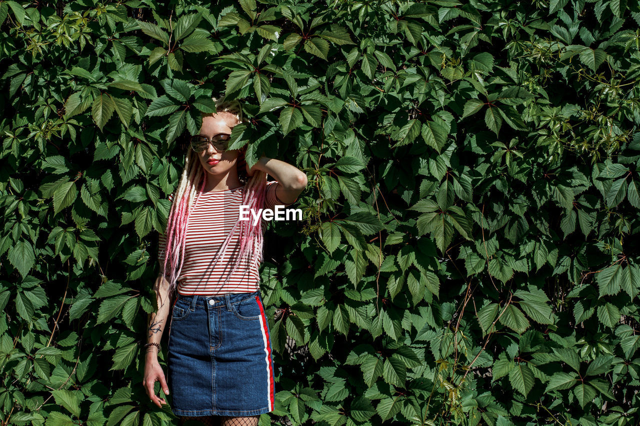 Full length of woman standing against plants