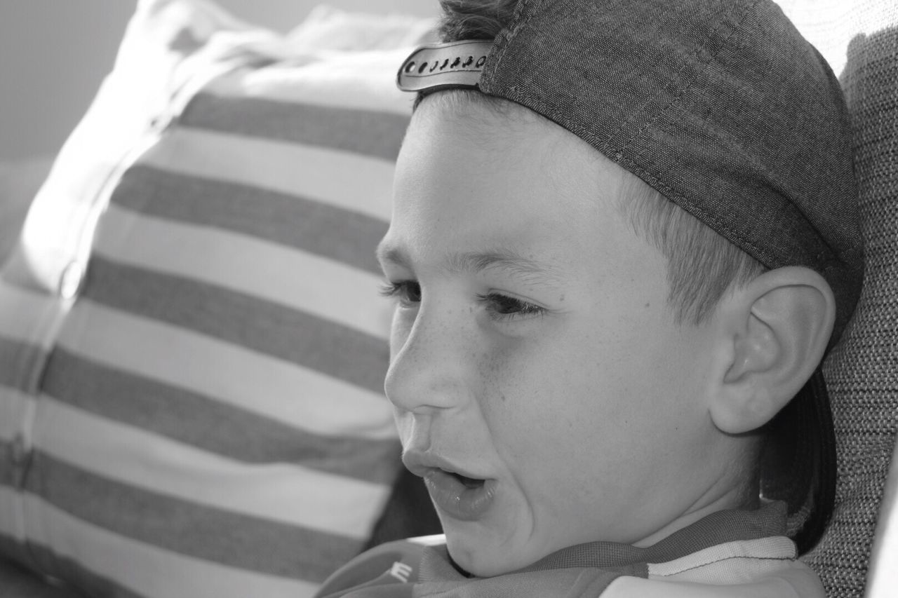 Close-up of boy looking away while making face at home