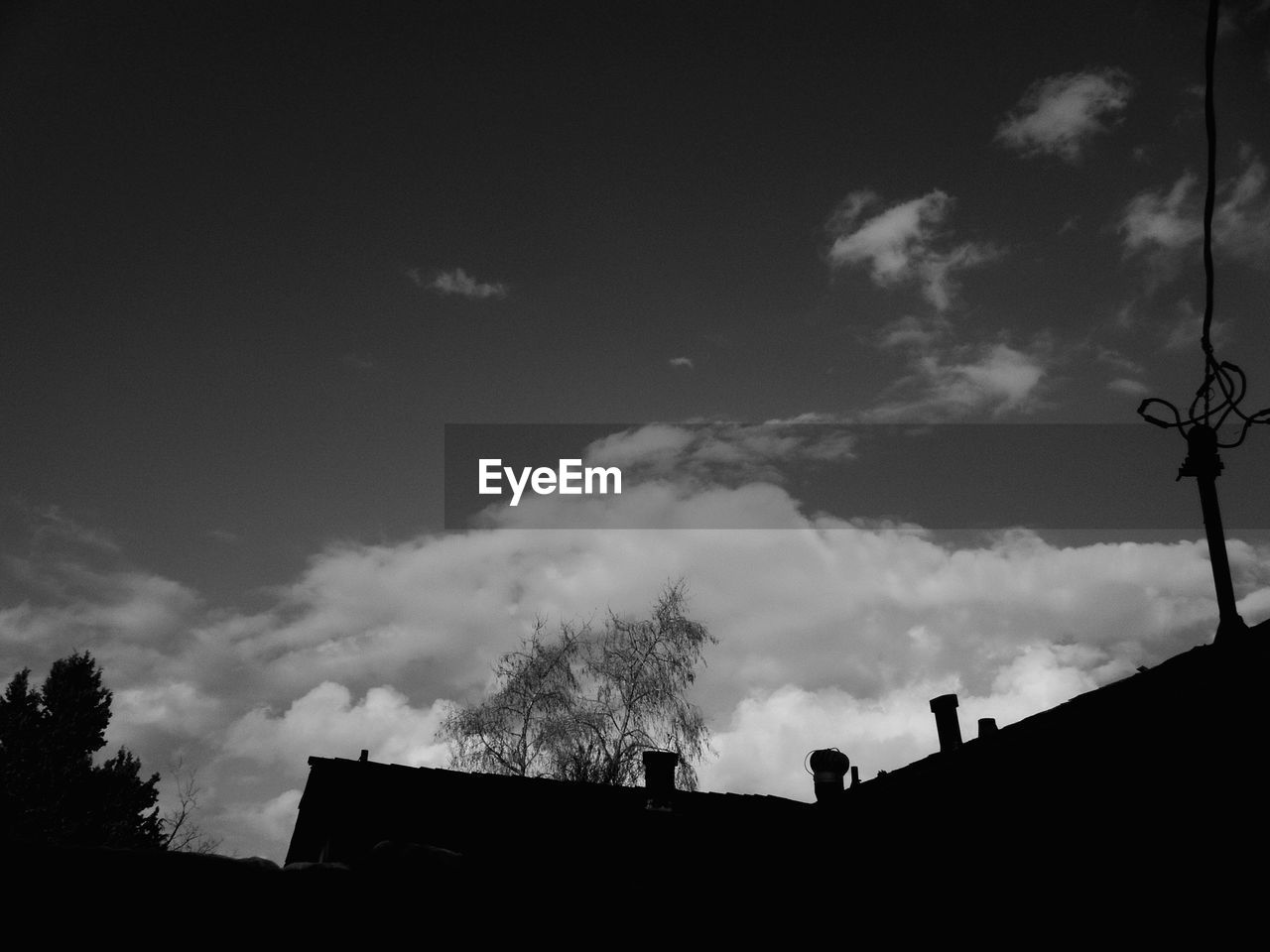Low angle view of silhouette house against sky