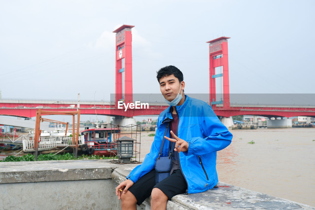 Relax on the banks of the musi river with the background of the palembang city icon ampera bridge