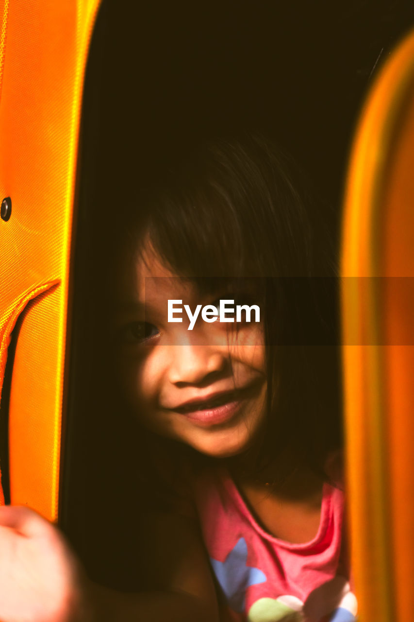 Close-up portrait of smiling girl indoors