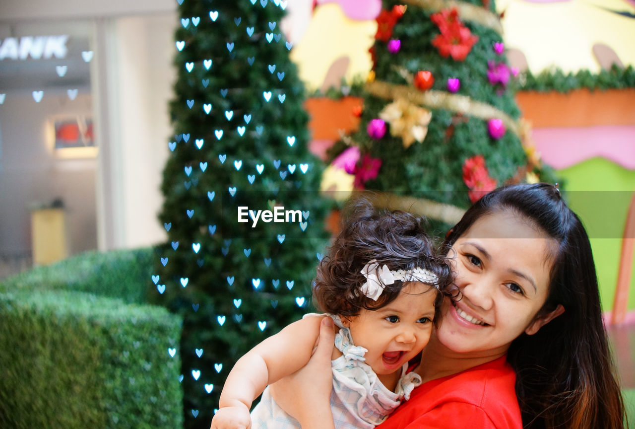 Close-up of baby girl with christmas tree