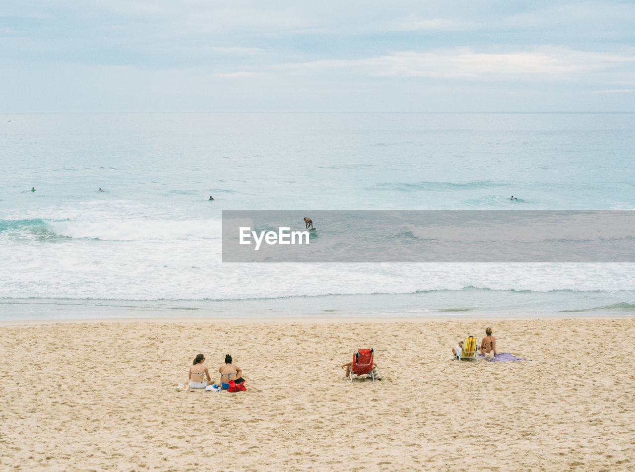 People at beach against sky