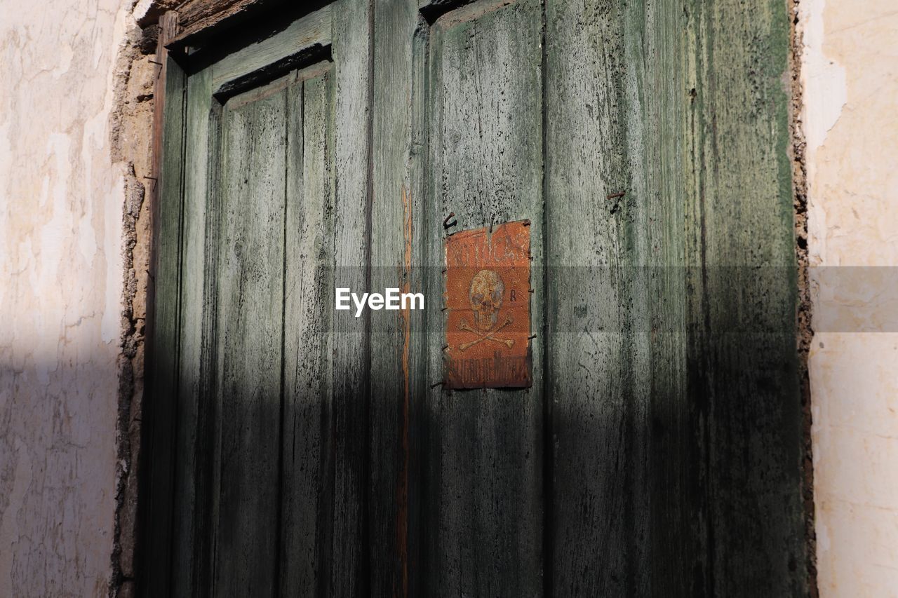 CLOSE-UP OF CLOSED DOOR OF OLD HOUSE