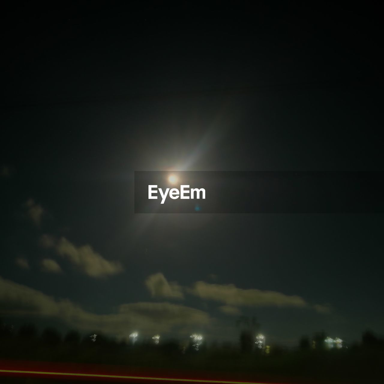 LOW ANGLE VIEW OF ILLUMINATED MOON IN SKY AT NIGHT