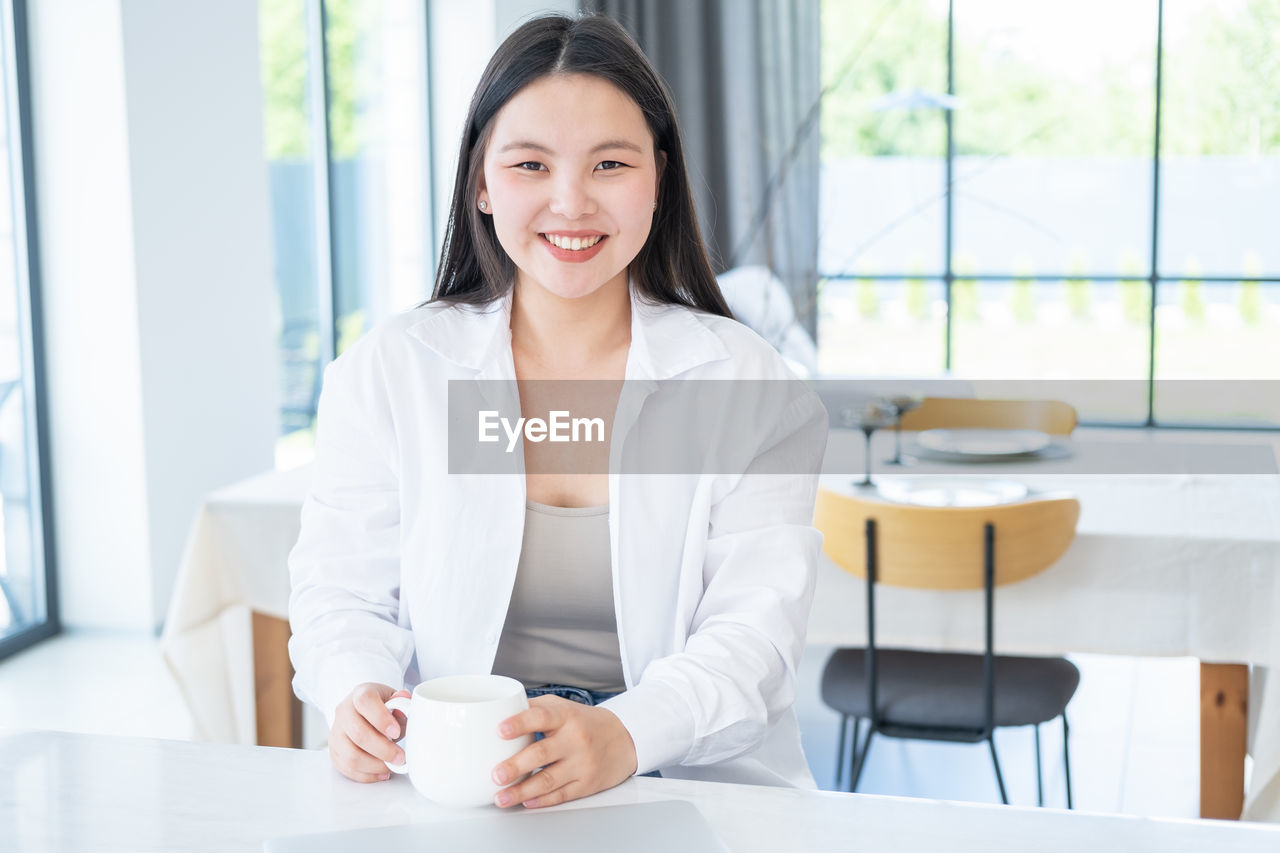 Portrait of young businesswoman sitting by table