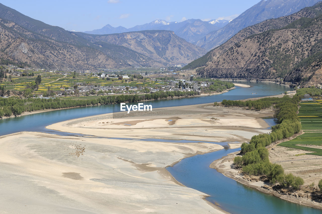 Scenic view of lake by mountains against sky