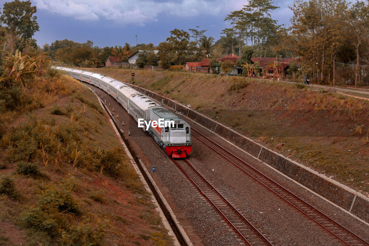 Train on railroad track amidst trees against sky