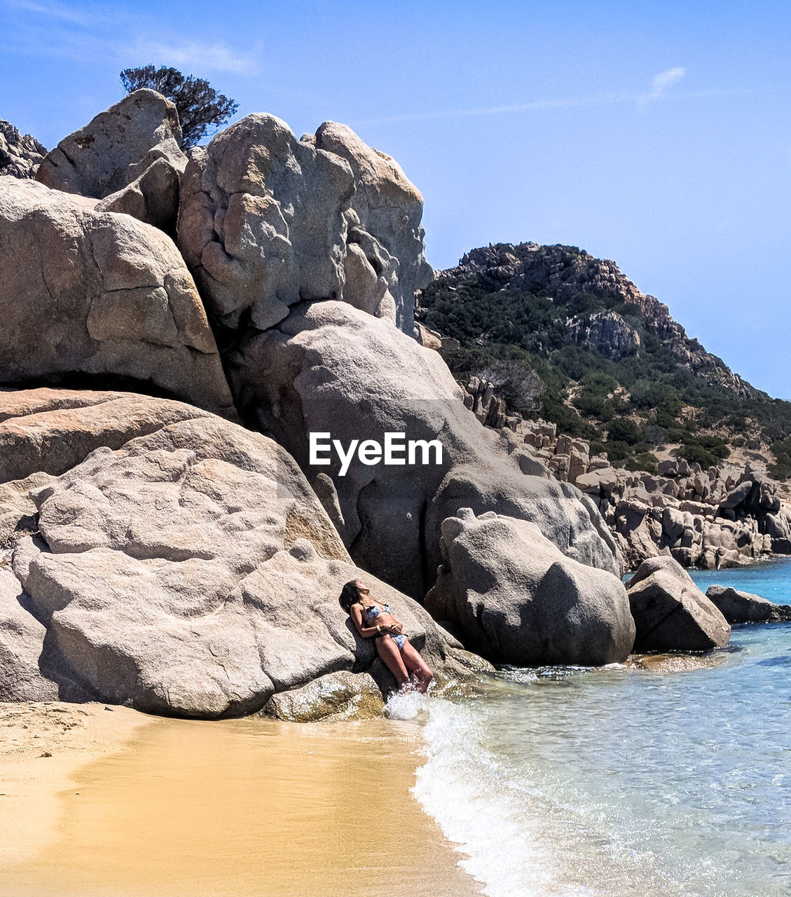 MAN STANDING ON ROCK AGAINST SKY