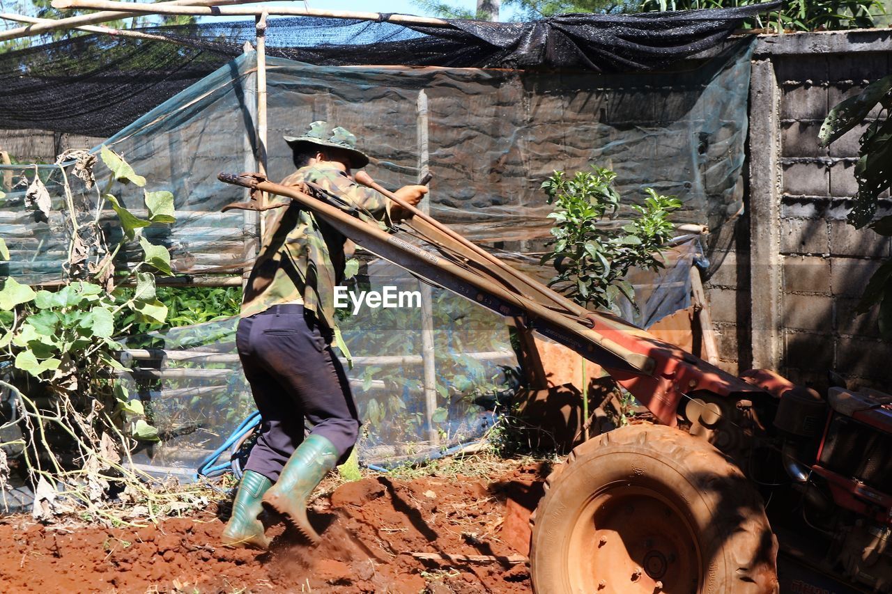 Side view of farmer working in farm