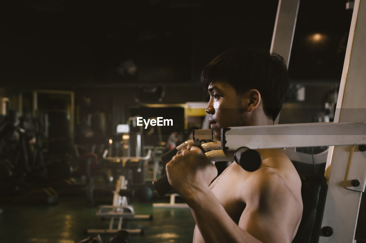 Shirtless man exercising in gym