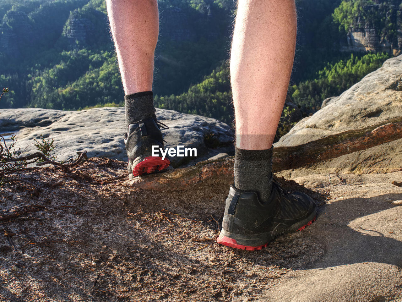 Young man strong legs off trail running at amazing summer sunset in sport and healthy lifestyle