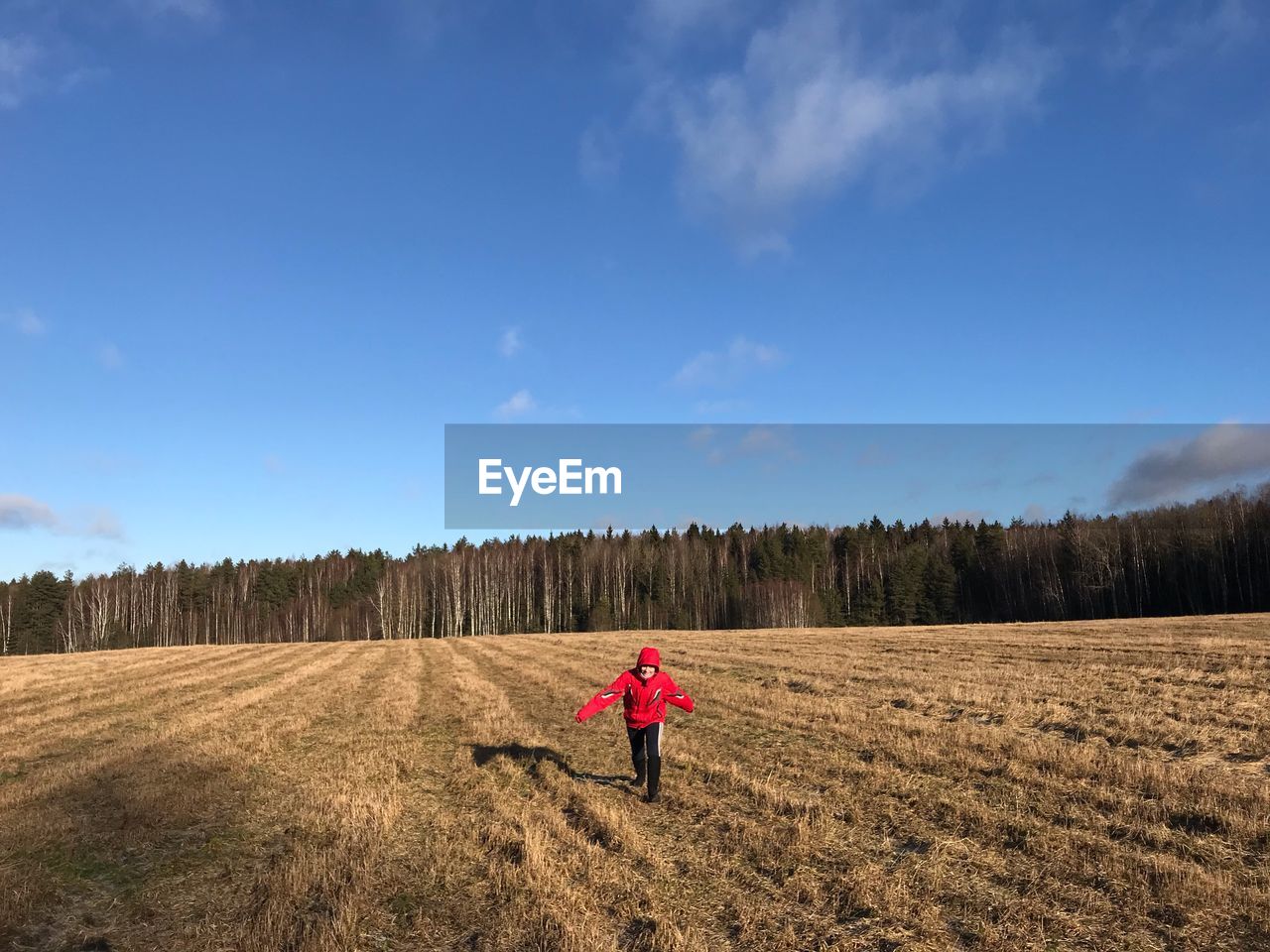 REAR VIEW OF WOMAN ON FIELD AGAINST SKY