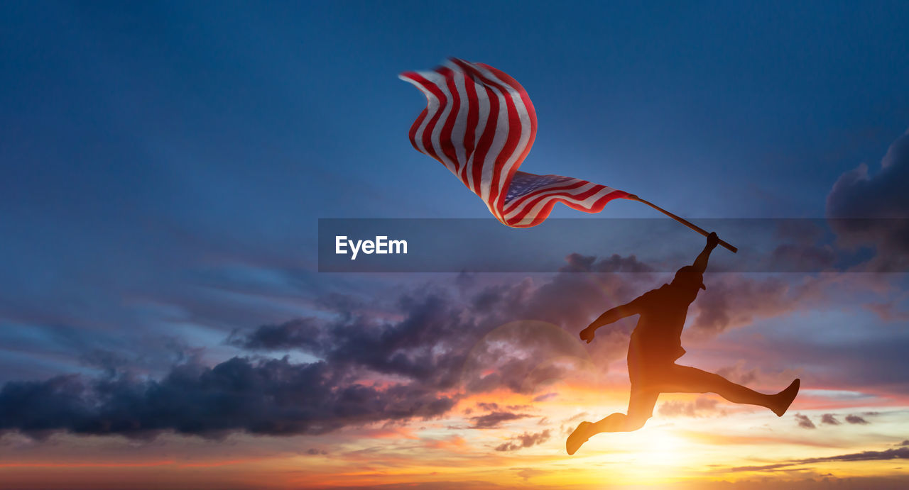 SILHOUETTE WOMAN FLYING AGAINST SKY AT SUNSET