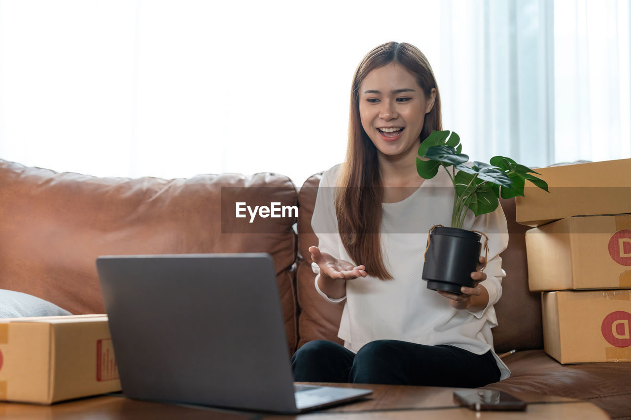 portrait of woman using laptop while sitting on table