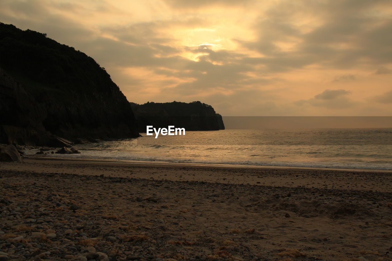 Scenic view of beach against sky during sunset