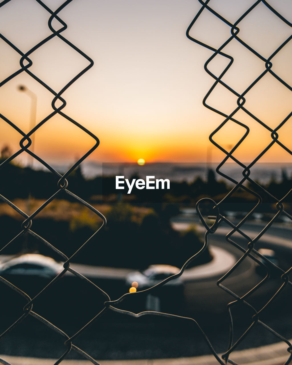 Close-up of chainlink fence during sunset