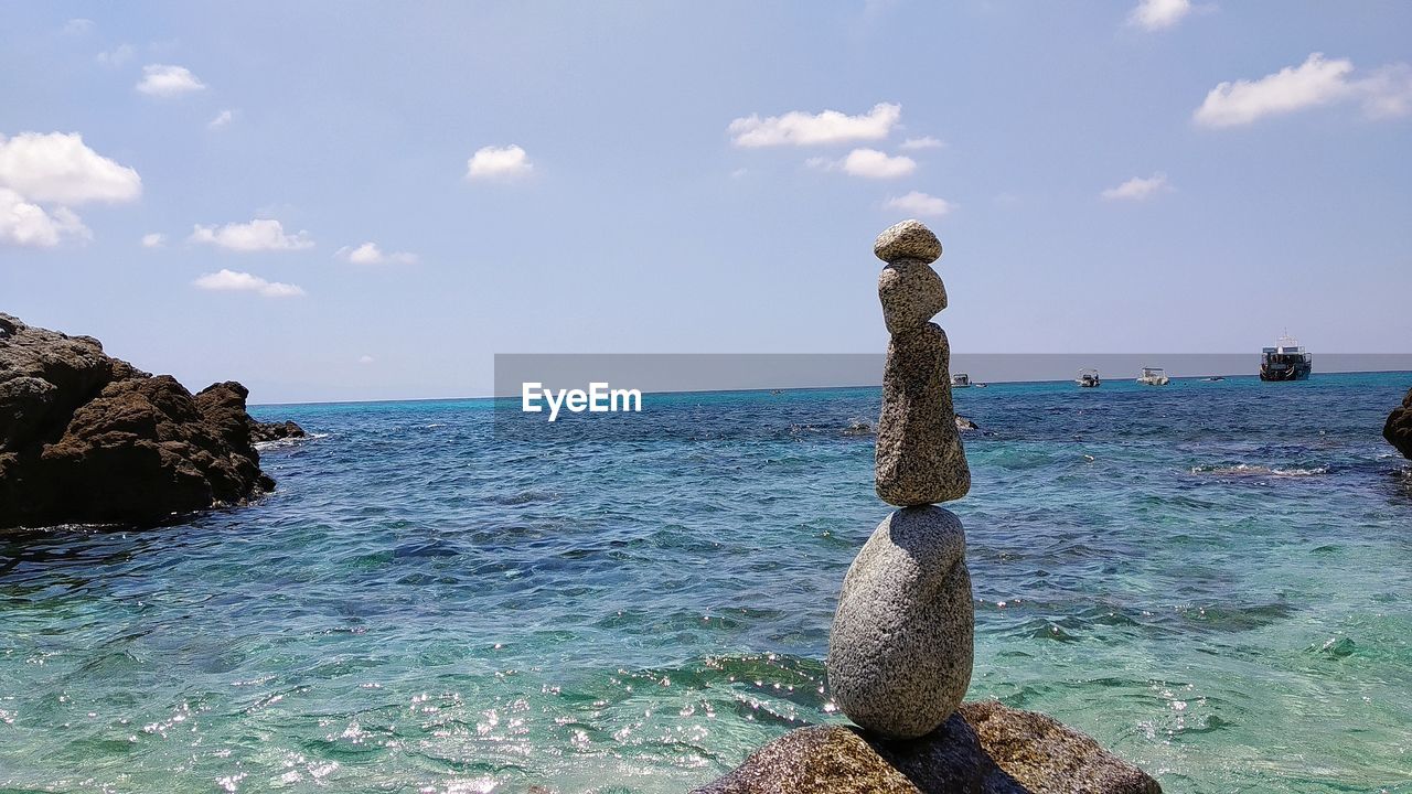 SCENIC VIEW OF ROCKS ON SEA AGAINST SKY