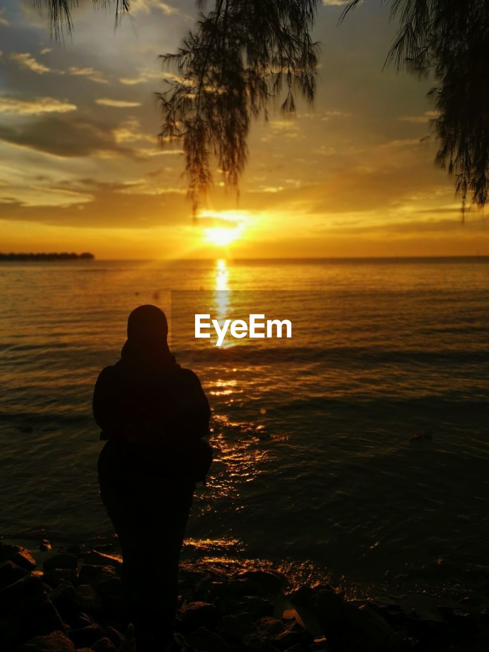 SILHOUETTE OF PERSON LOOKING AT SEA DURING SUNSET