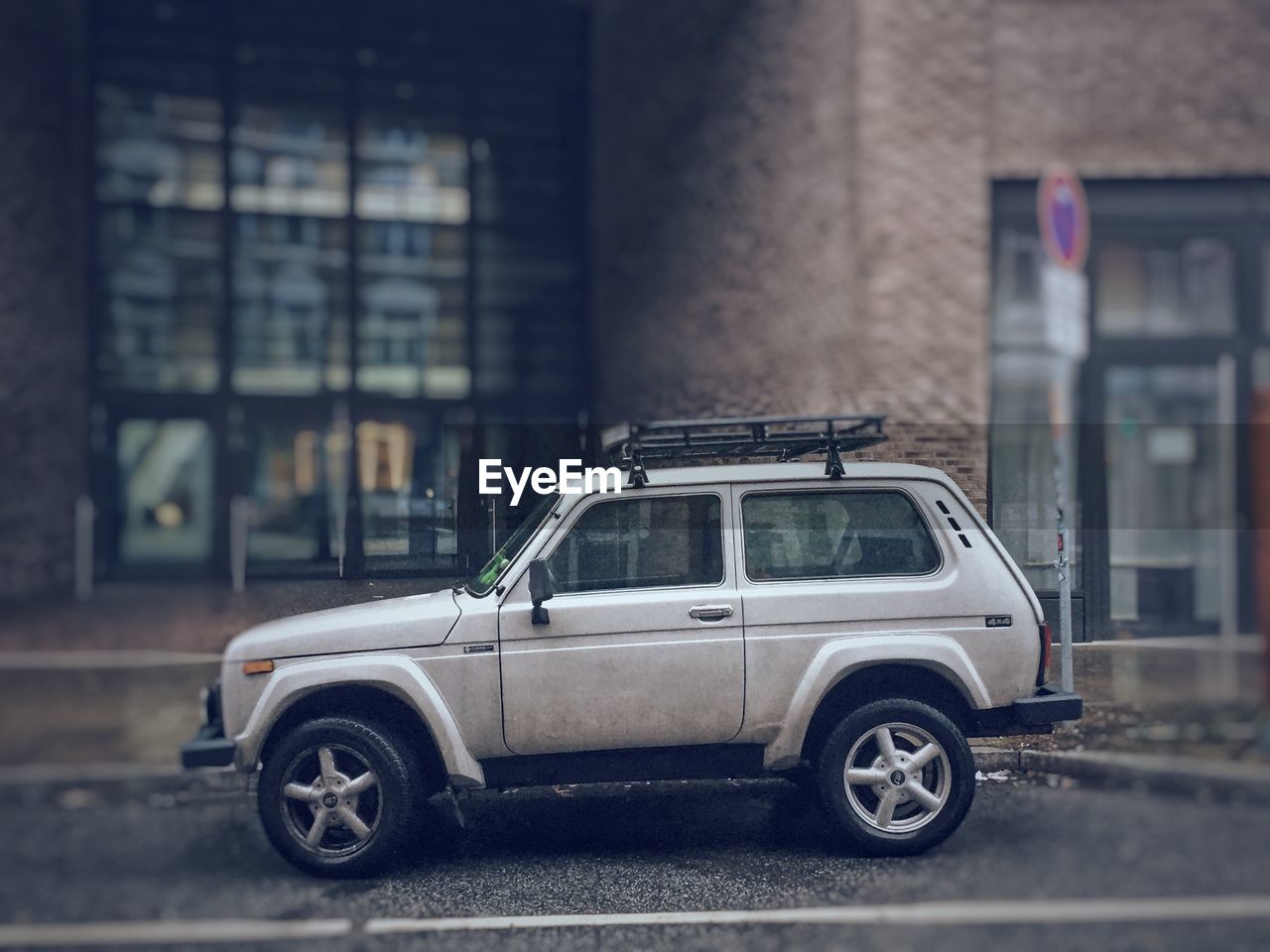 SIDE VIEW OF CAR ON ROAD AGAINST BUILDING