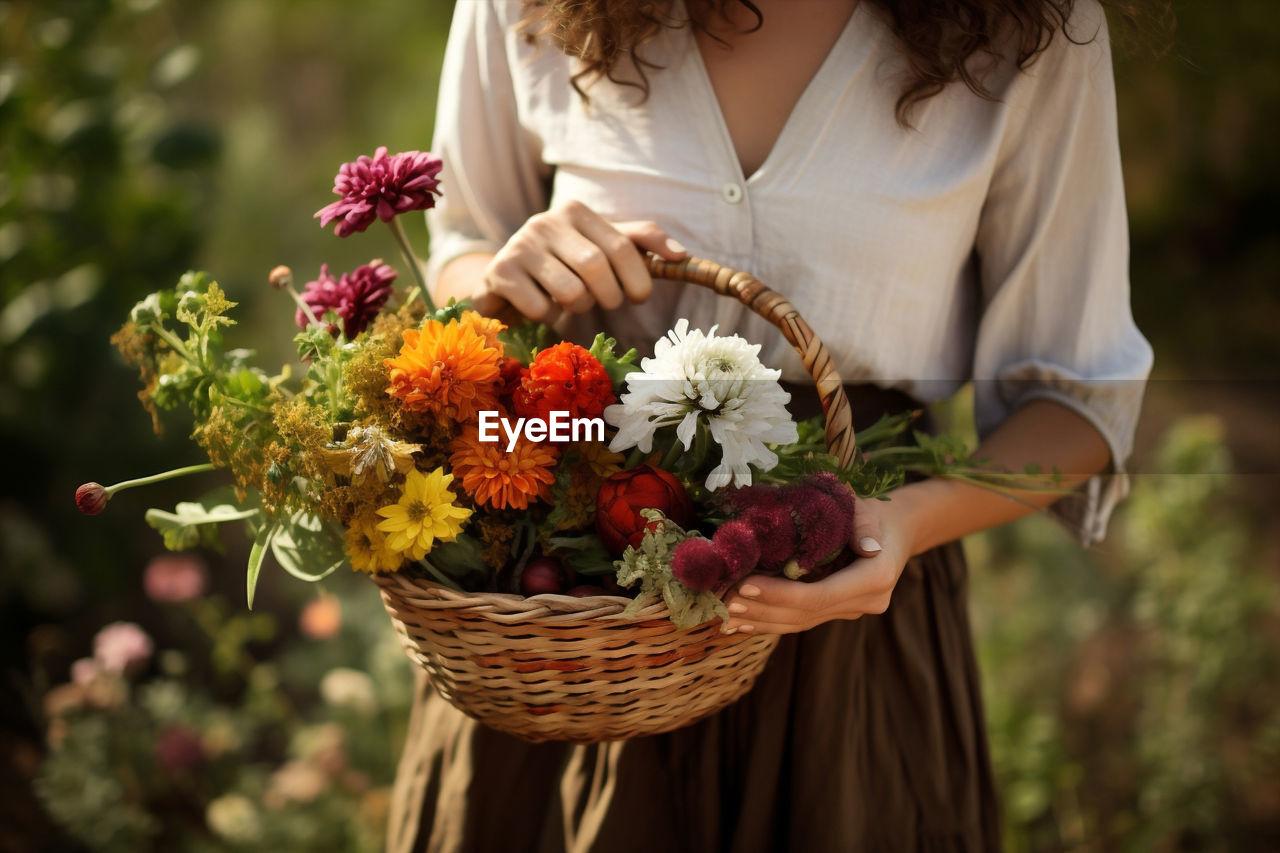 midsection of woman holding bouquet at home