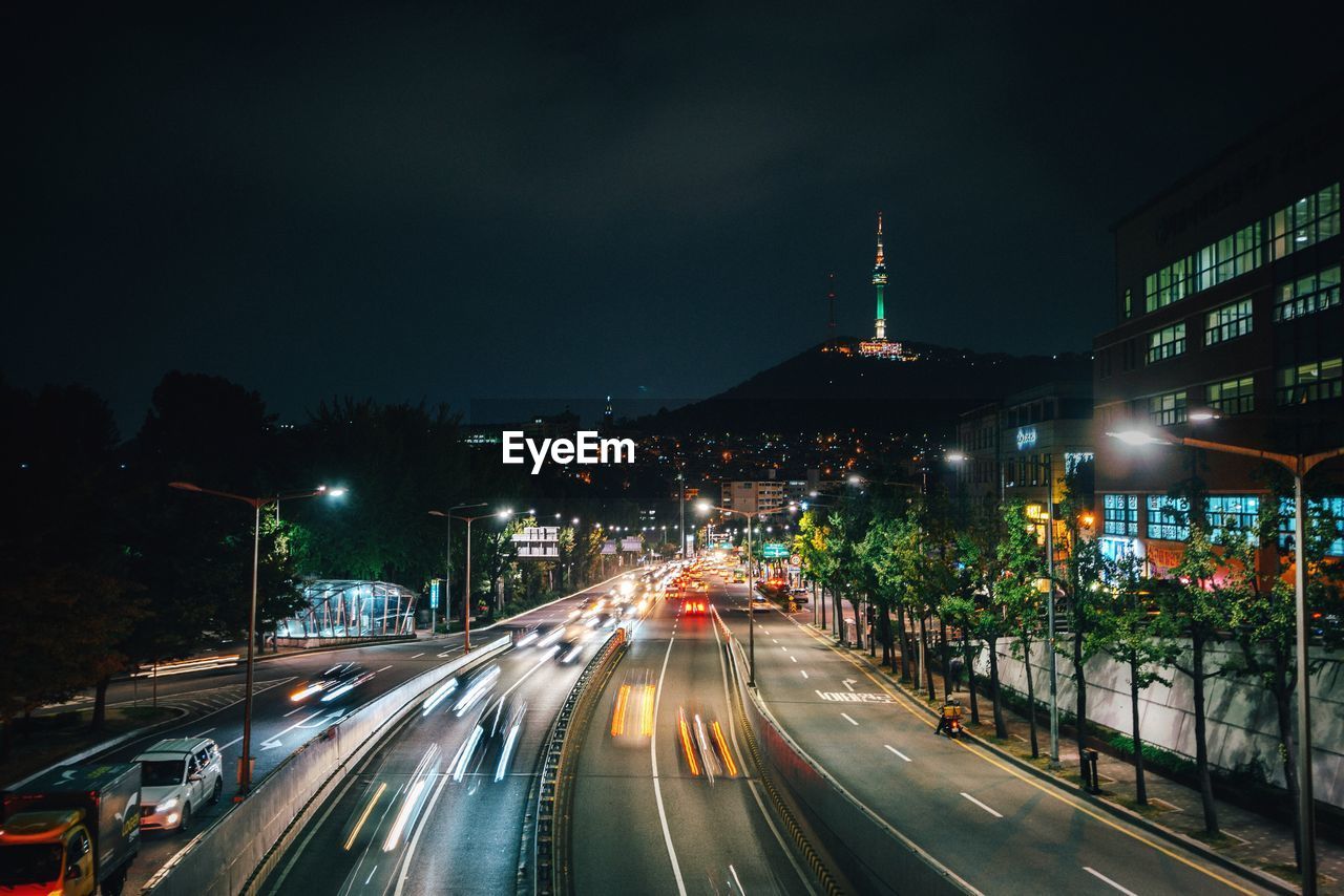 Distant view of n seoul tower with city street in foreground at night