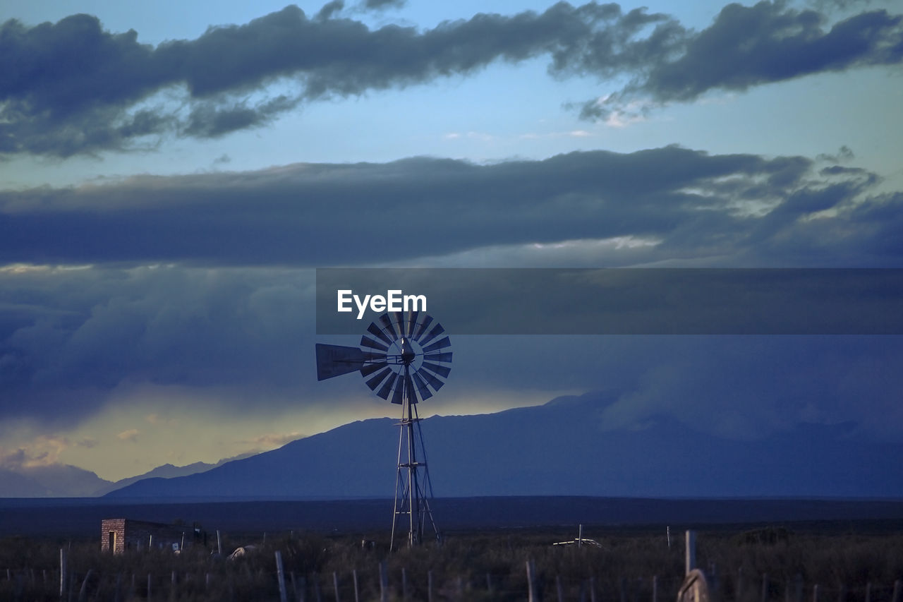 WINDMILL ON LANDSCAPE AGAINST SKY DURING SUNSET