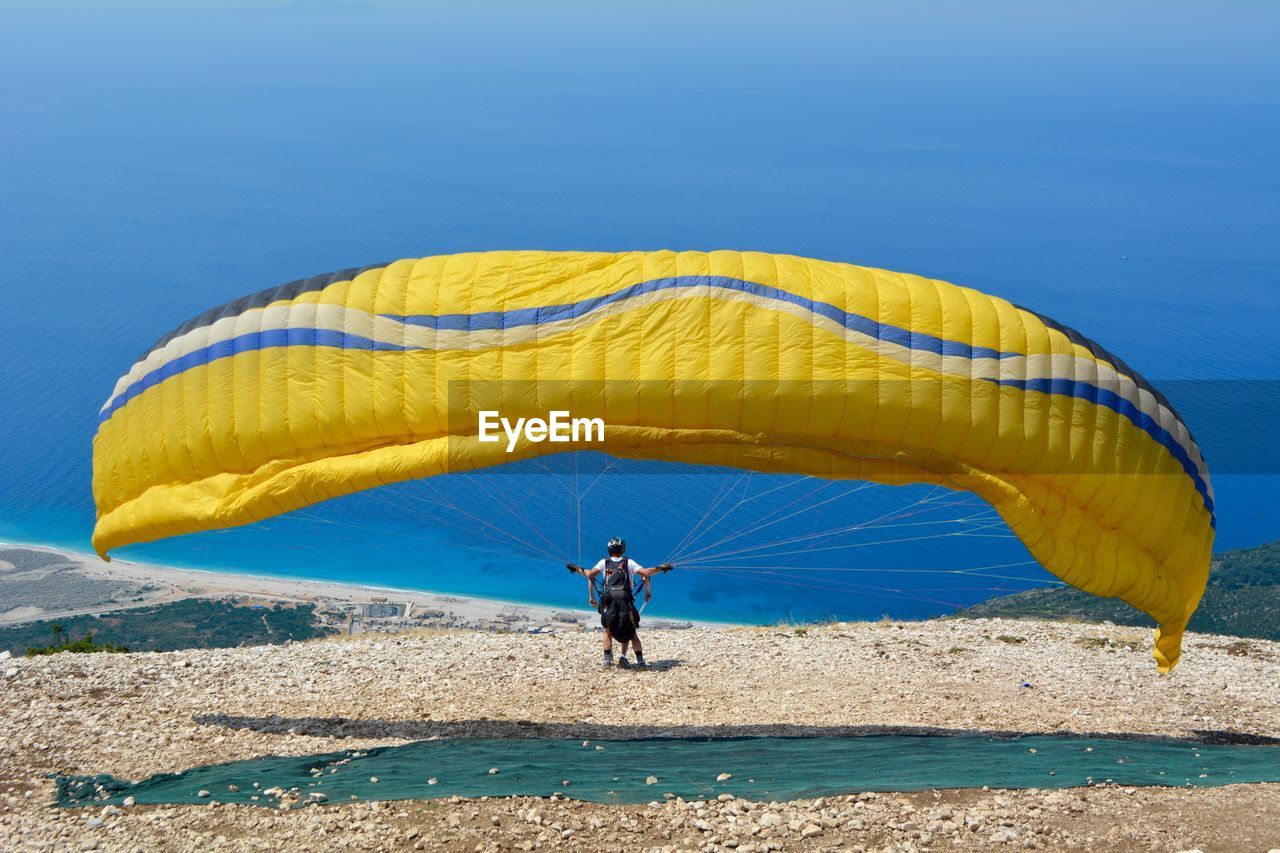 Boy with parachute against sea