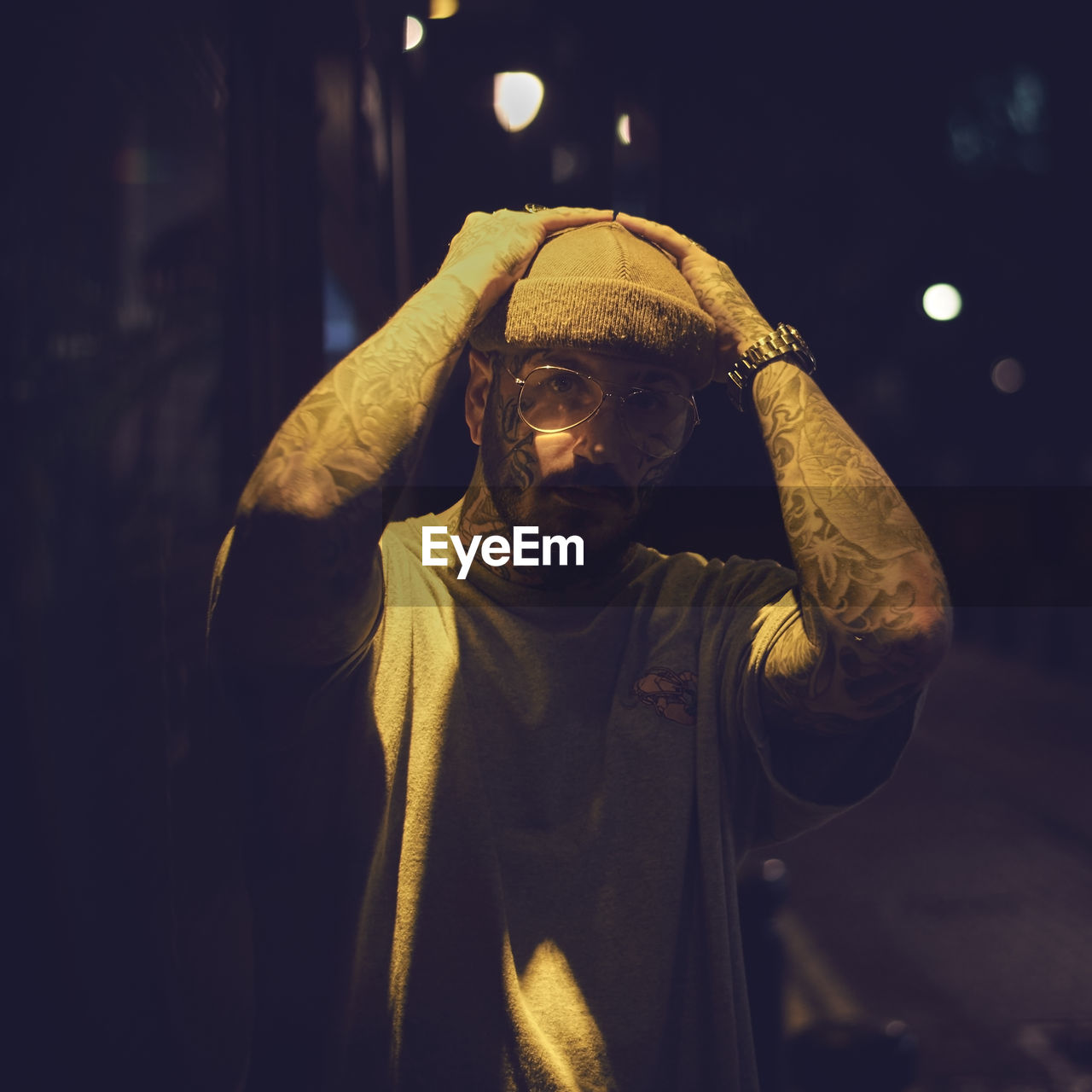 Man standing on illuminated street at night