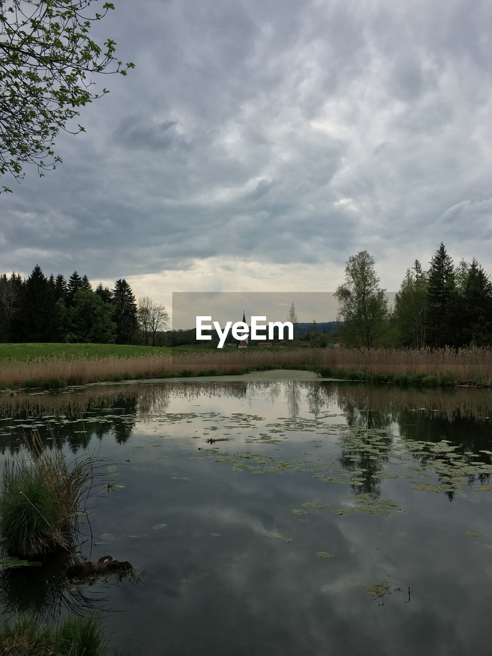 TRANQUIL VIEW OF LAKE AGAINST CLOUDY SKY