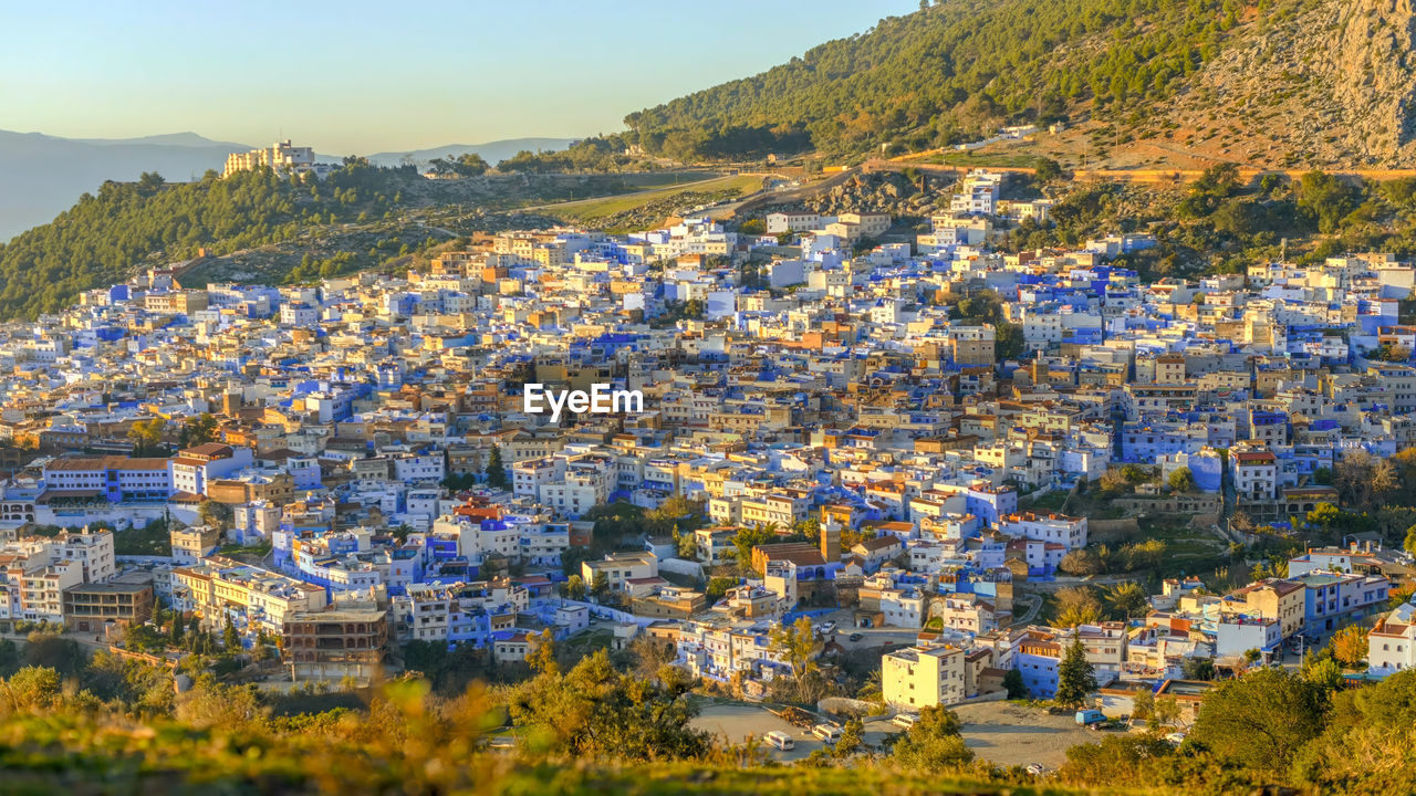 high angle view of townscape by sea against sky