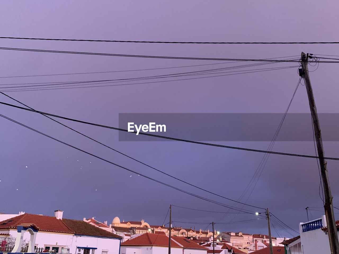 cable, electricity, architecture, sky, power line, technology, built structure, power supply, nature, building exterior, power generation, line, electricity pylon, no people, overhead power line, building, lighting, city, outdoors, dusk, low angle view, house, electrical supply, communication, clear sky