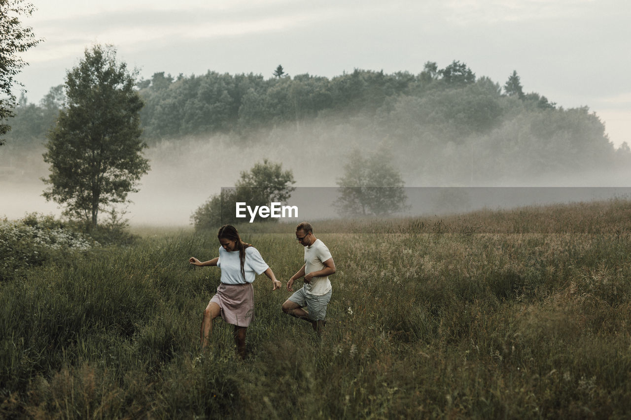 Couple walking through meadow