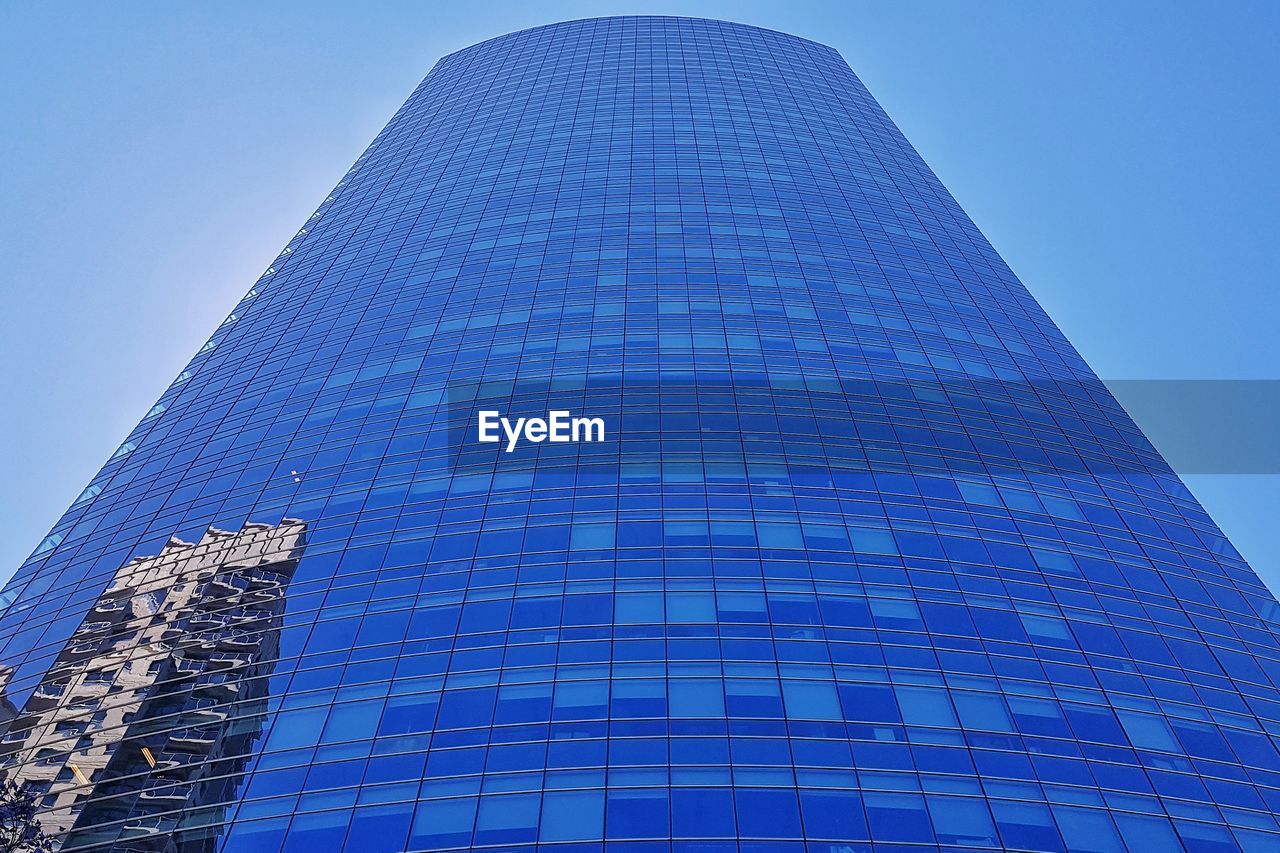 Low angle view of modern building against blue sky