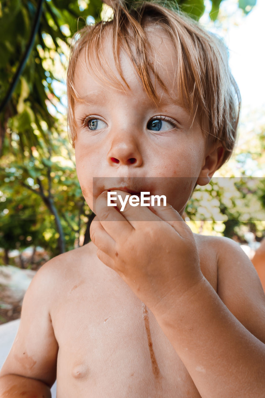Little boy eating a berry
