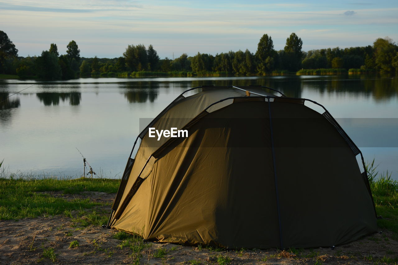 Tent by river against sky
