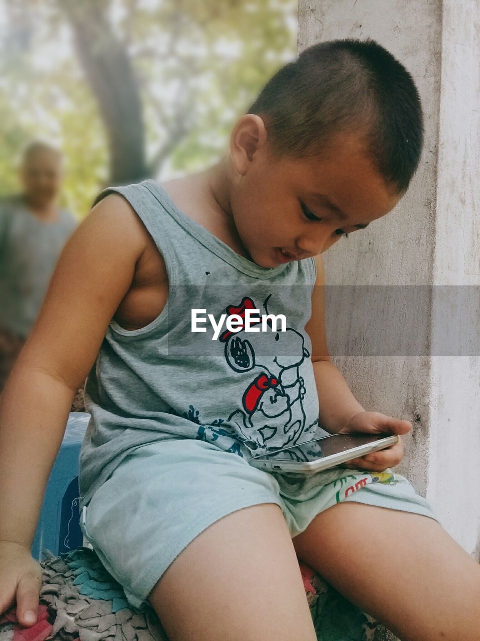 Boy sitting with mobile phone