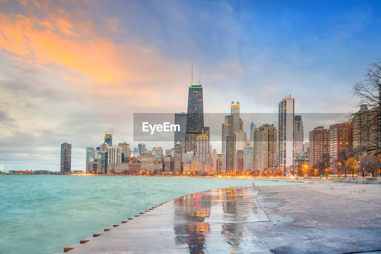 SEA AND BUILDINGS AGAINST SKY IN CITY