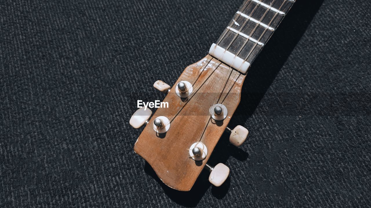 HIGH ANGLE VIEW OF GUITAR ON THE FLOOR