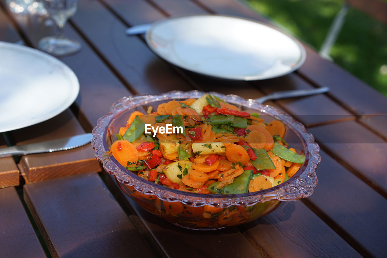 Close-up of fresh salad served in bowl on table in back yard
