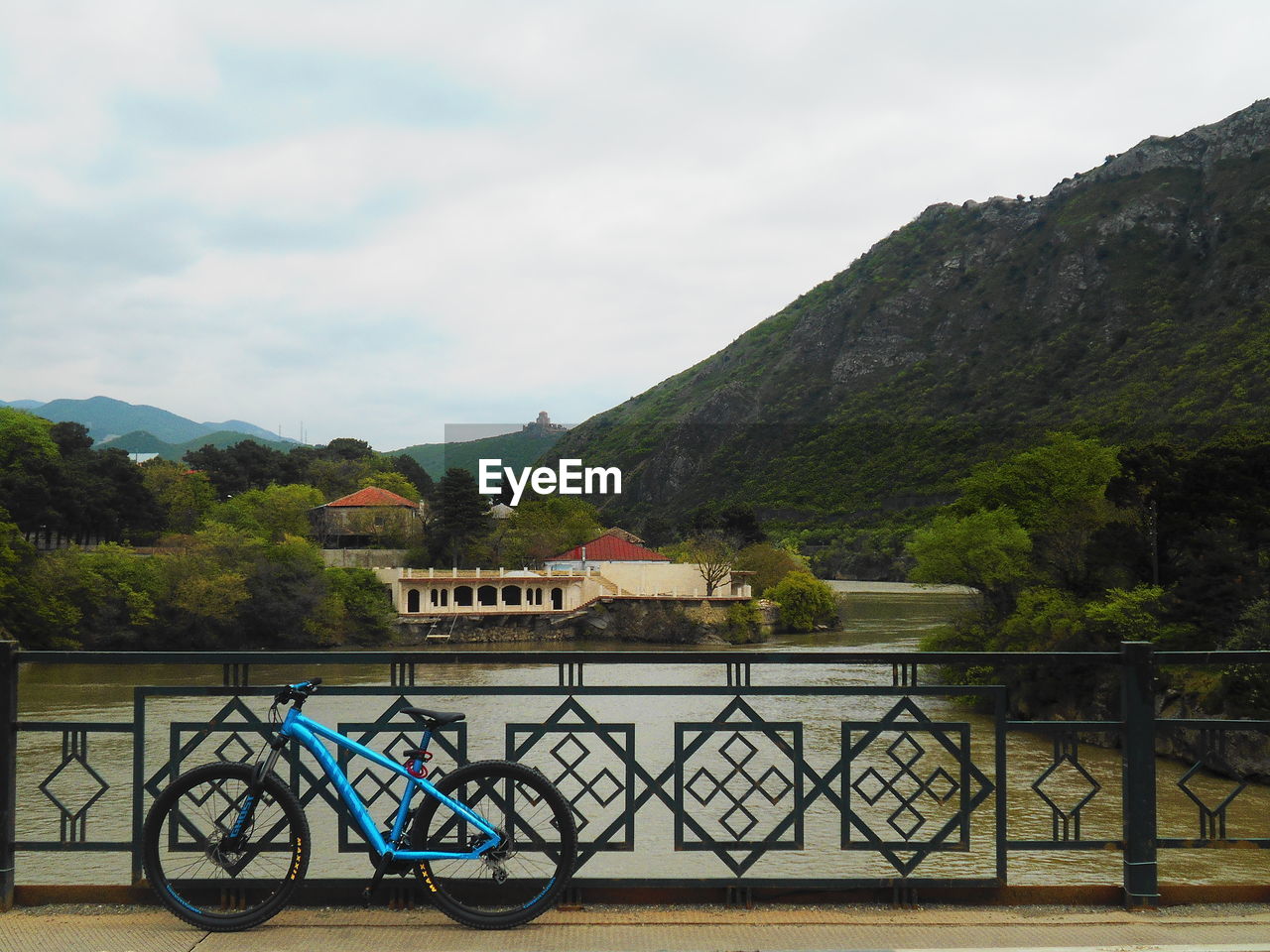 BICYCLE BY RAILING AGAINST MOUNTAINS