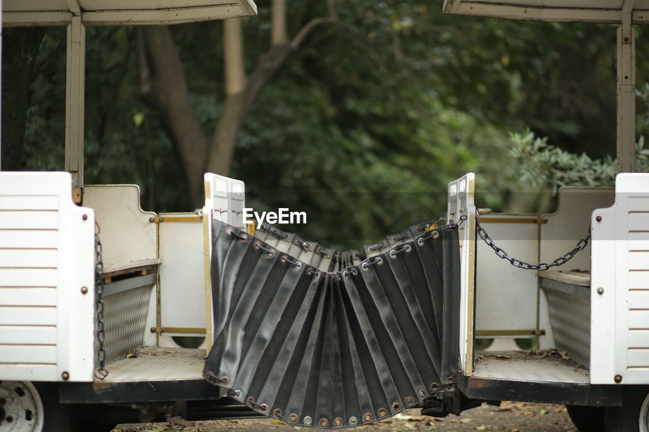 METALLIC STRUCTURE BY TREES AGAINST BUILDING