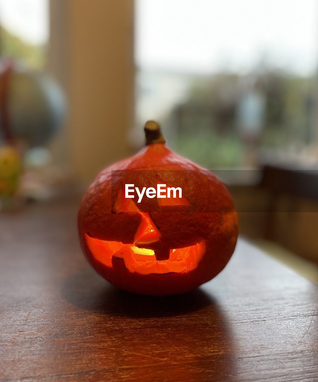 CLOSE-UP OF PUMPKIN ON TABLE AT HOME DURING HALLOWEEN