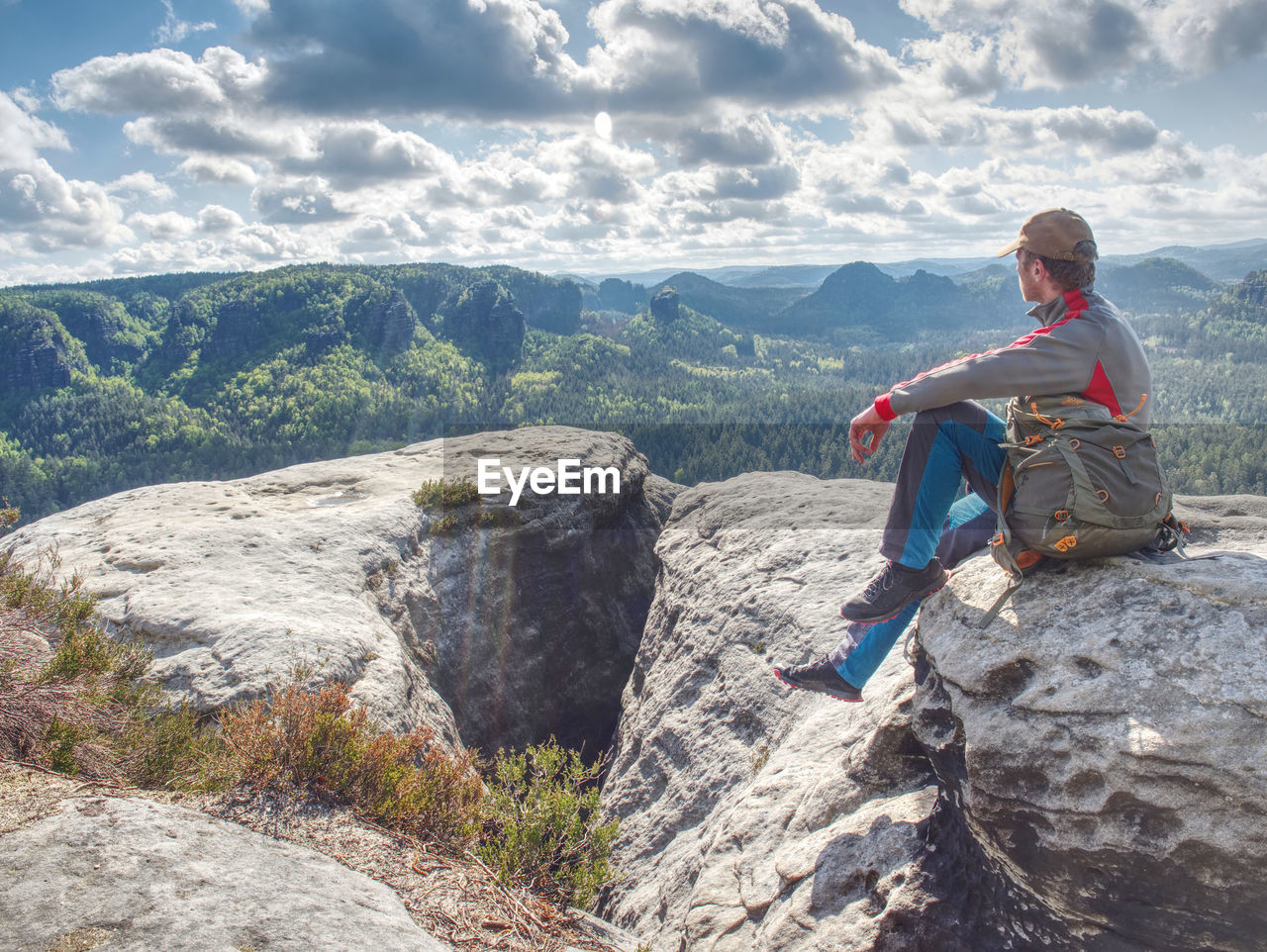 Tourist man looking at view of far mountains, norway. hikking, relax on trip